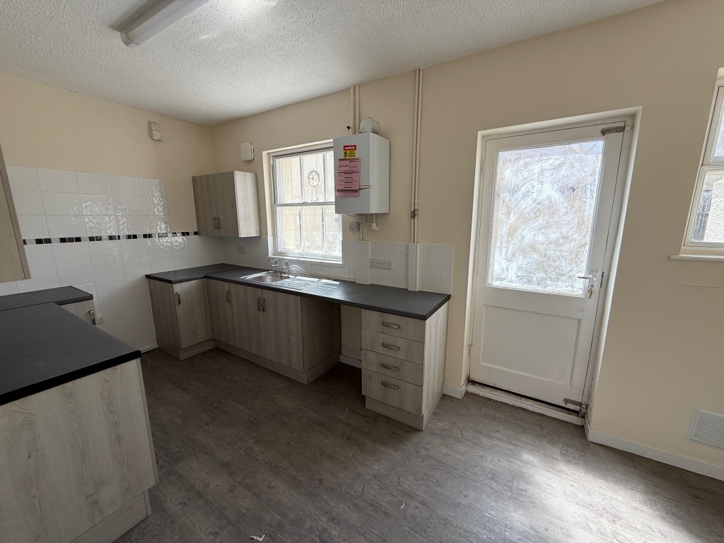 Lot: 127 - THREE-BEDROOM END-TERRACE COTTAGE FOR IMPROVEMENT - Kitchen with gas boiler, back door and two windows to rear